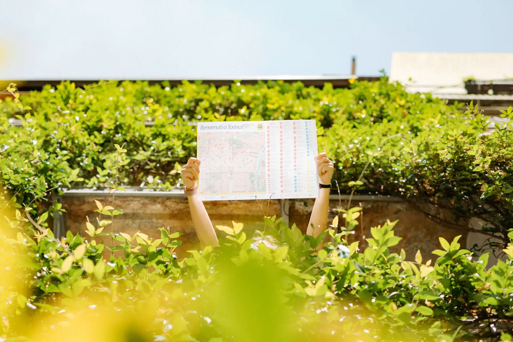 Ospite del Tomato Urban Retreat legge una mappa di Torino nel giardino dell’ostello, in San Salvario
