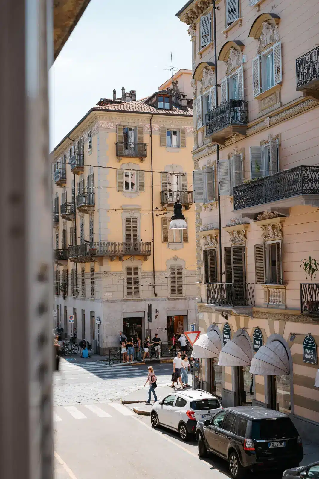 Scorcio di San Salvario a Torino visto dalla finestra del Tomato Urban Retreat, con palazzi storici e caff&egrave; sotto i portici