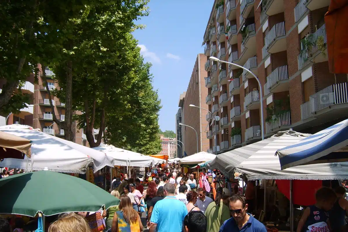 Il mercato di Porta Portese a Roma: banchi e ombrelloni lungo la strada in una mattina di domenica