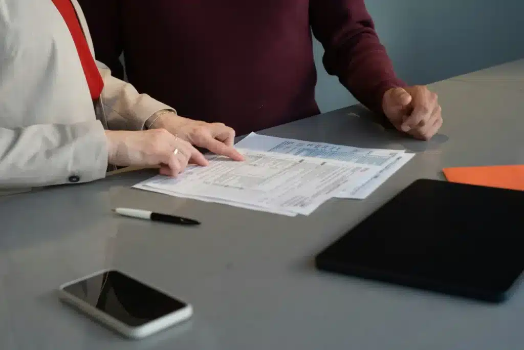 Due persone sedute a un tavolo consultano dei documenti durante una consulenza